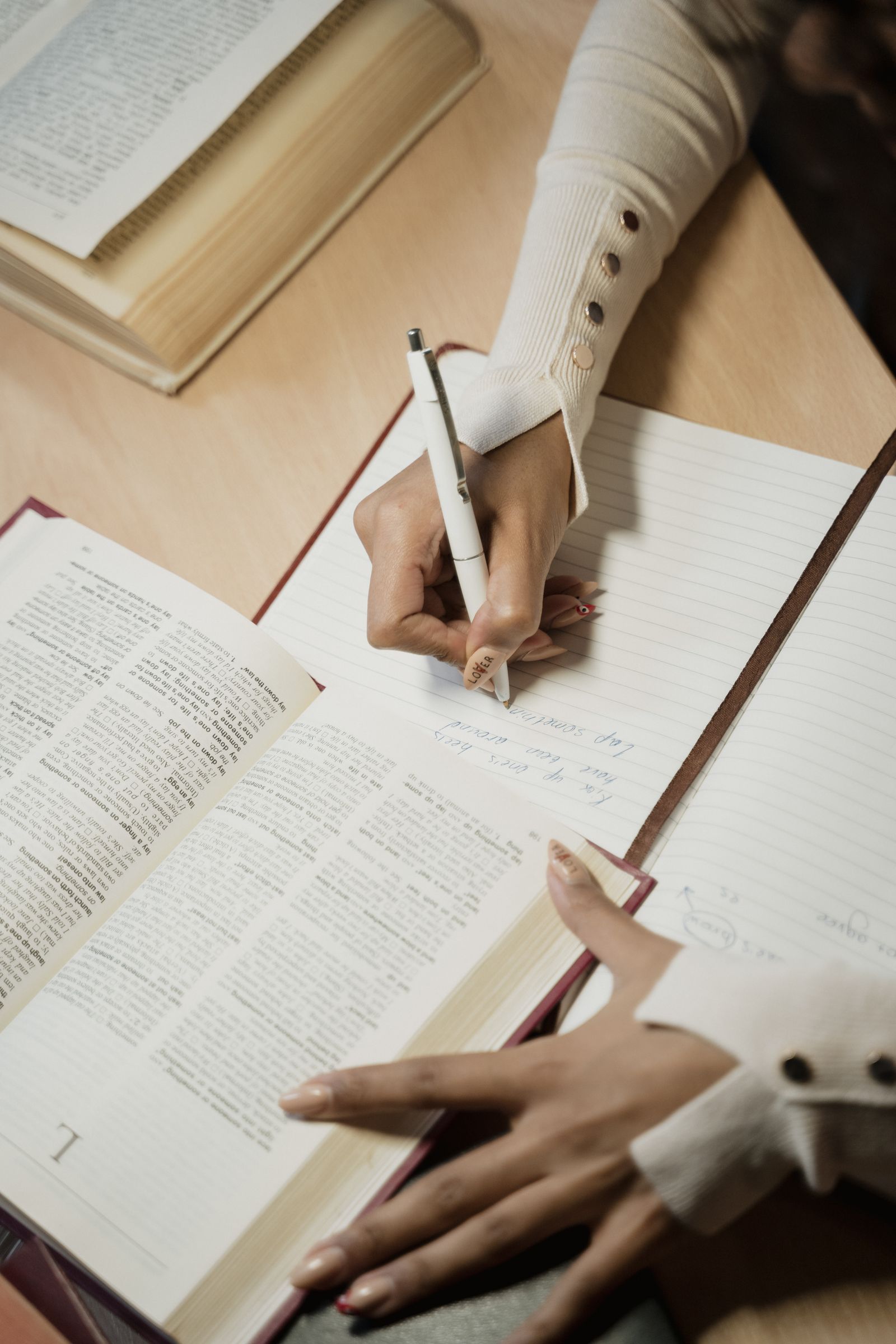 A woman writing notes beside an open Bible during personal study